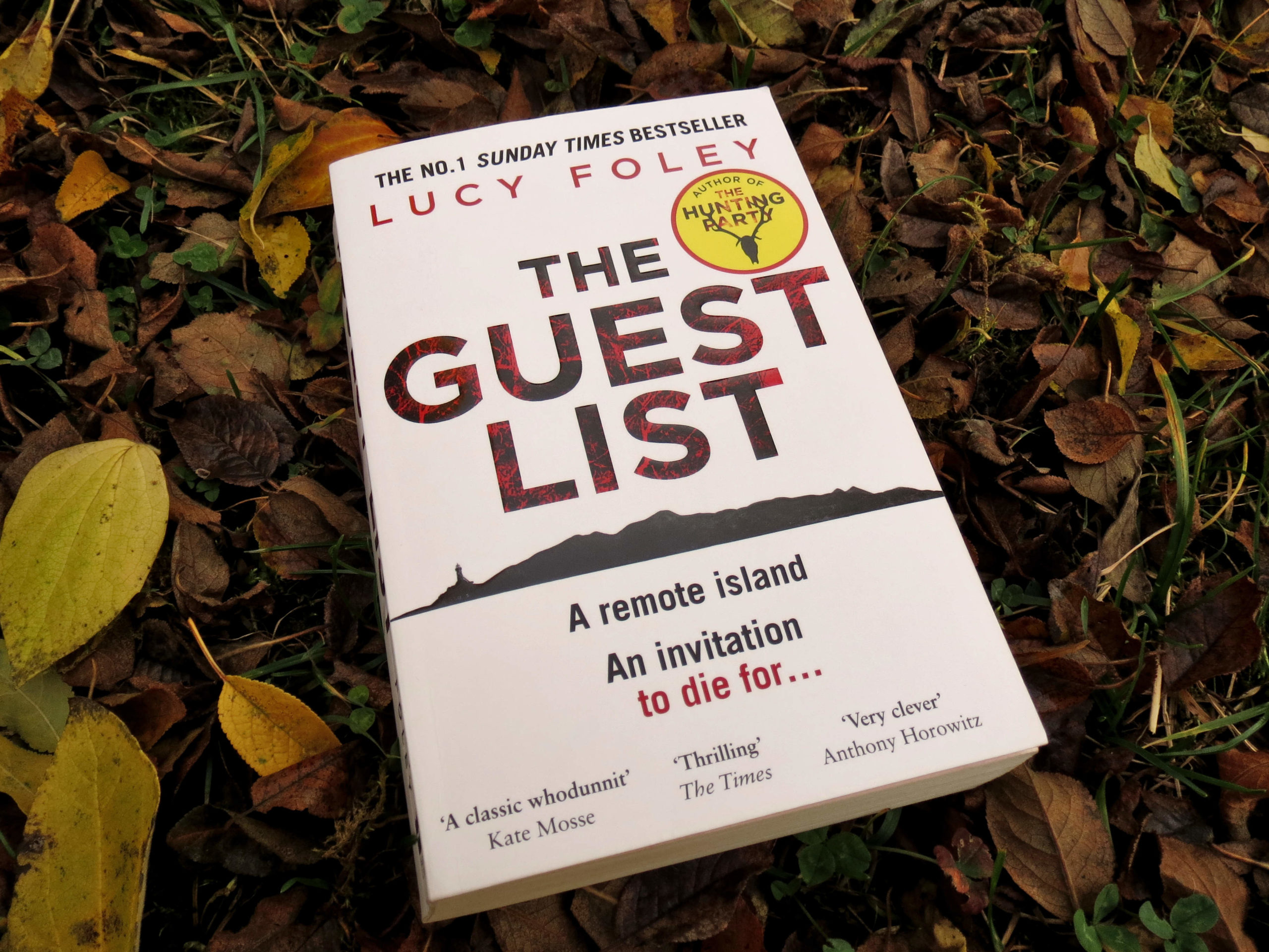 "The Guest List" von Lucy Foley liegt in einer Wiese voller herbstlichem Laub